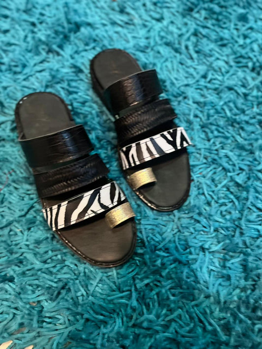 Sandalia dedo tiras cuero negro c/cebra y dorado